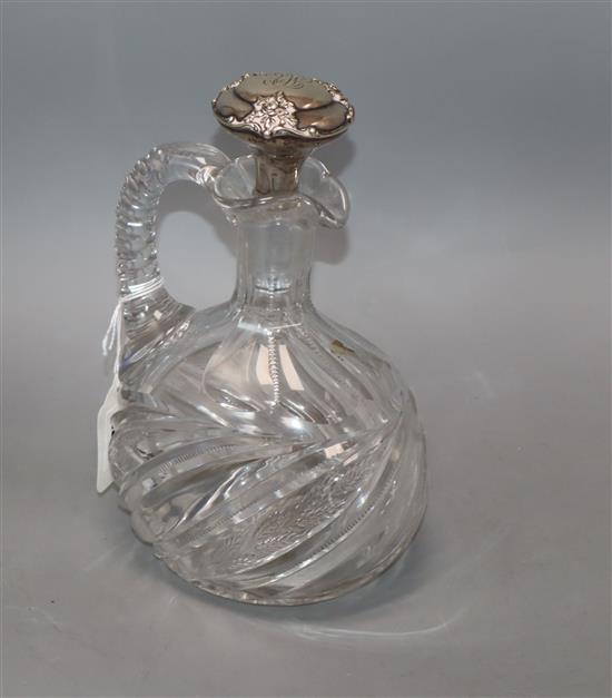 A cut glass decanter jug with sterling mounted stopper,